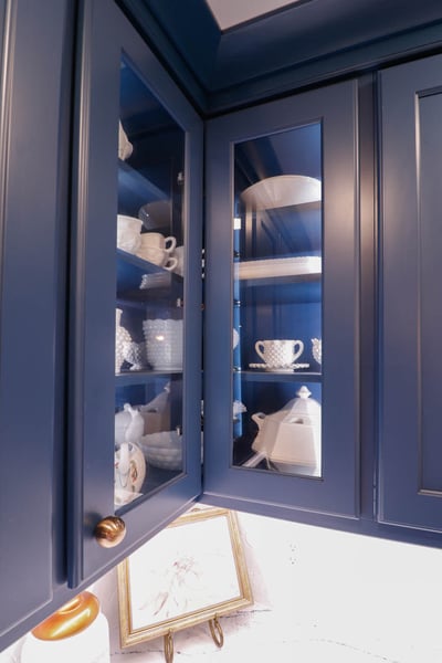 Glass-front kitchen cabinets in a Tacoma Hills, MI custom home by Odd Fellows Contracting displaying white dishware.