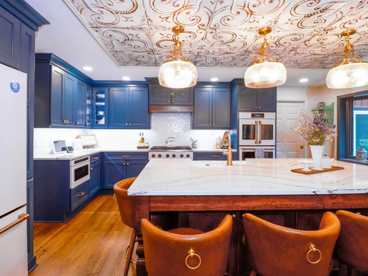 Kitchen remodel in a Tacoma Hills, MI custom home by Odd Fellows Contracting featuring blue cabinetry and a marble island.