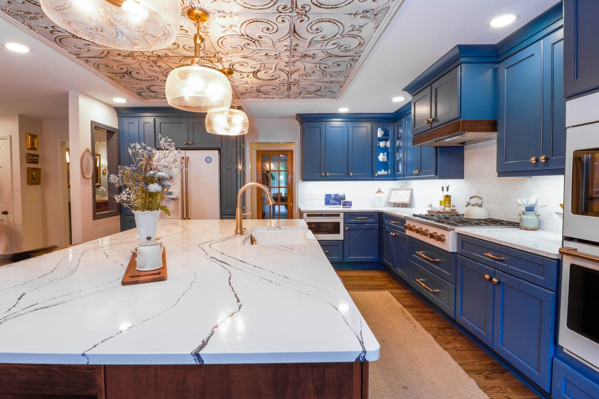 Kitchen remodel in a Tacoma Hills, MI custom home by Odd Fellows Contracting with blue cabinetry and quartz island.