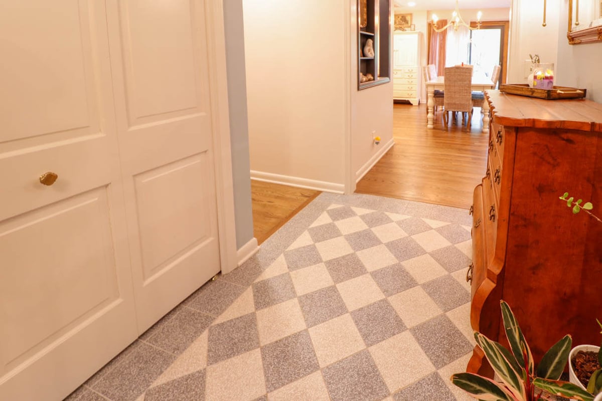 Updated hallway flooring in a Tacoma Hills, MI custom home by Odd Fellows Contracting with patterned tile design.
