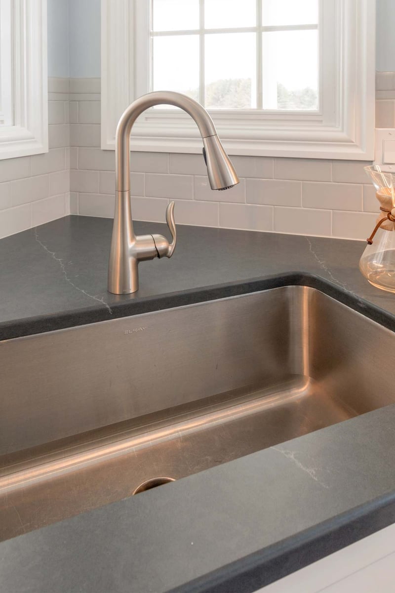 Close up of stainless kitchen faucet and undermount sink in Bath Township kitchen remodel by Odd Fellows Contracting