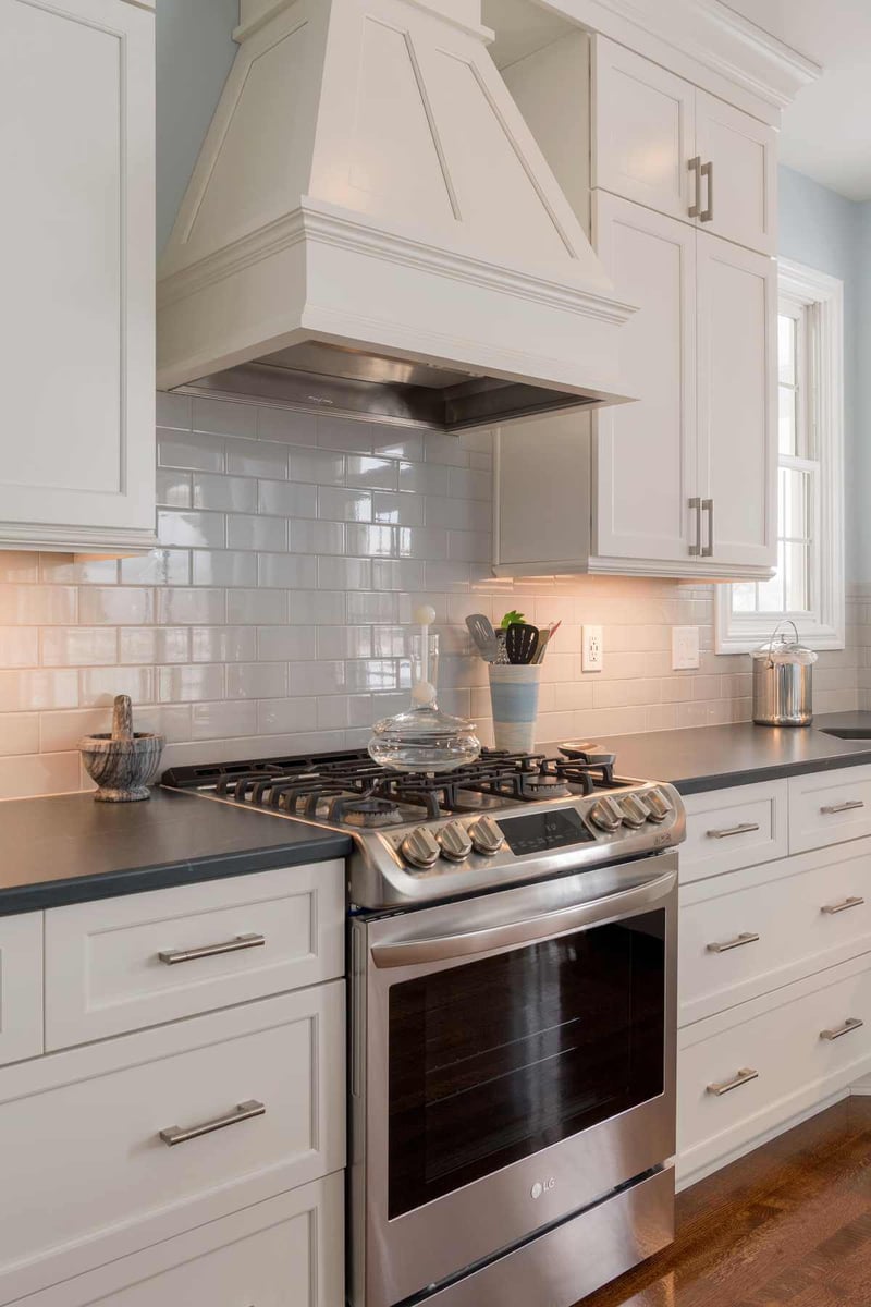 Custom kitchen range hood with subway tile backsplash in Bath Township remodel by Odd Fellows Contracting