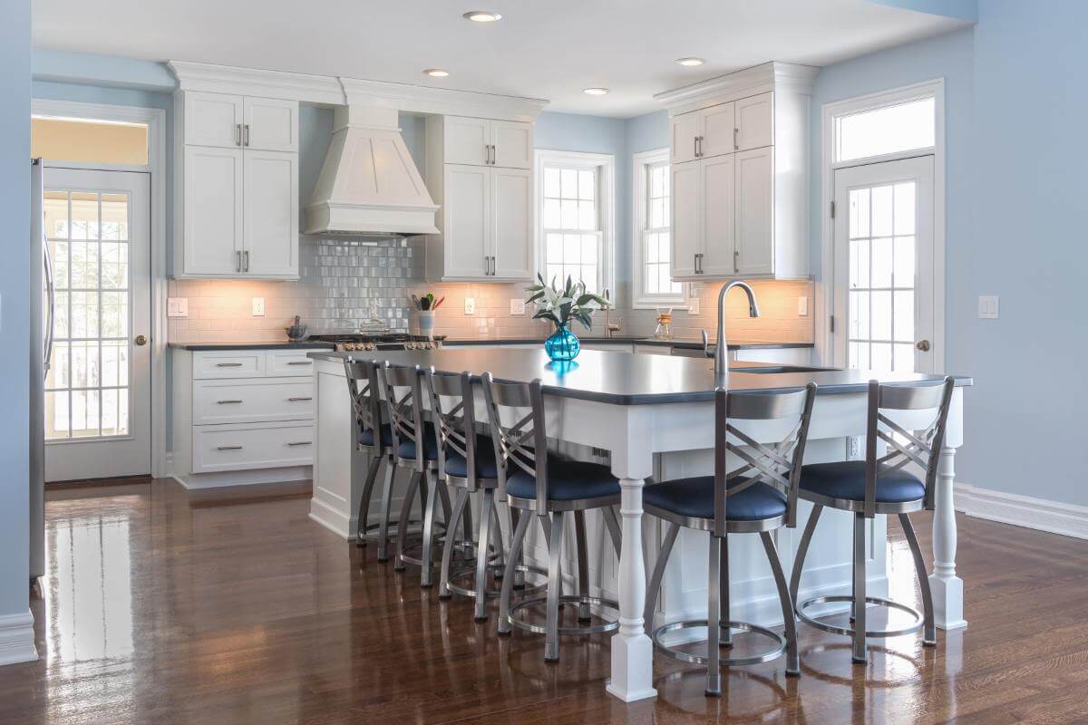 Large kitchen island with seating and white cabinets in Bath Township kitchen remodel by Odd Fellows Contracting in Williamston MI