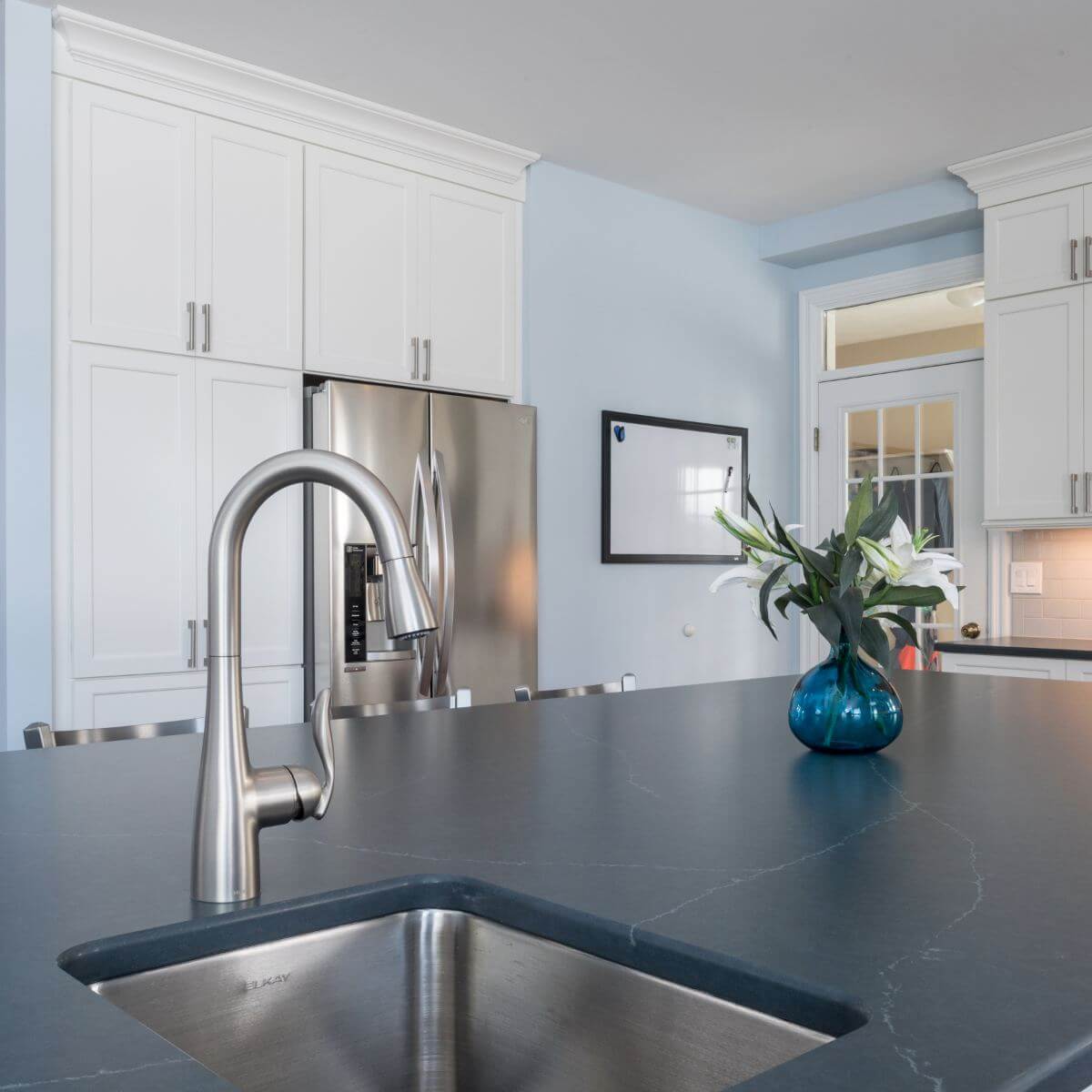 Stainless steel sink and faucet installed in quartz countertop during Bath Township kitchen remodel by Odd Fellows Contracting