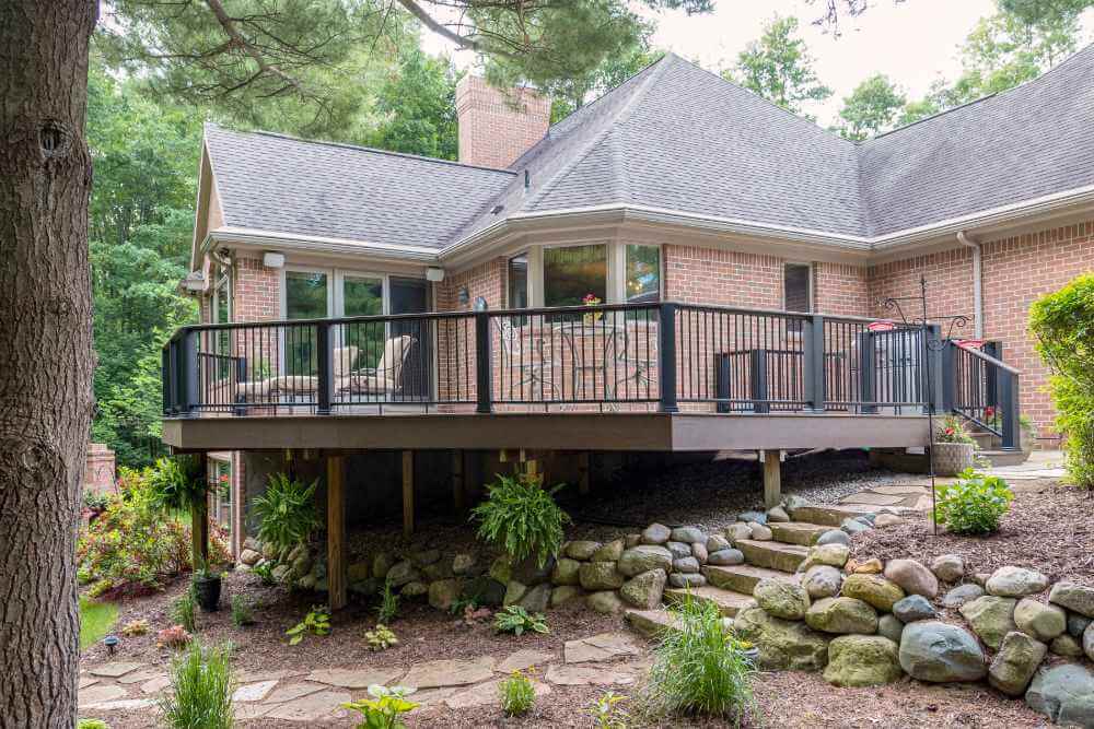 Elevated composite deck with black metal railing installed by Odd Fellows Contracting in Williamston, MI