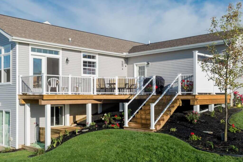 Elevated backyard deck with white railing and stairs built by Odd Fellows Contracting in Mason, MI