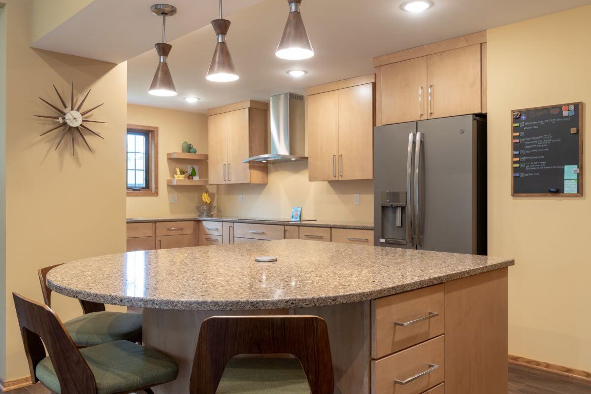 Granite kitchen island with bar seating in modern East Lansing Michigan kitchen remodel by Odd Fellows Contracting Granite kitchen island with bar seating in modern East Lansing Michigan kitchen remodel by Odd Fellows Contracting
