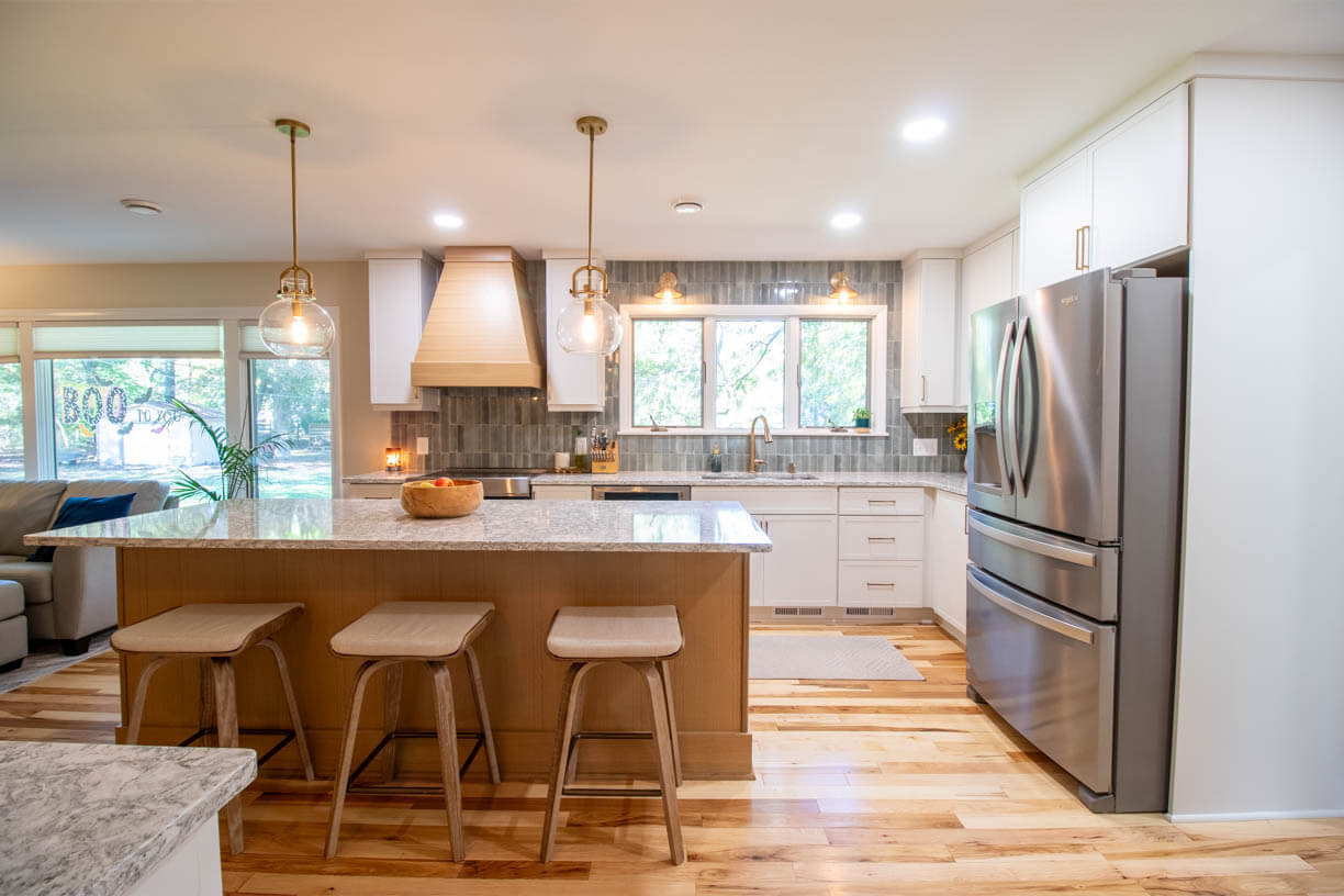 finished kitchen remodel by Odd Fellows Contracting in Hiawatha Lakes, Okemos, MI with quartz island and custom range hood
