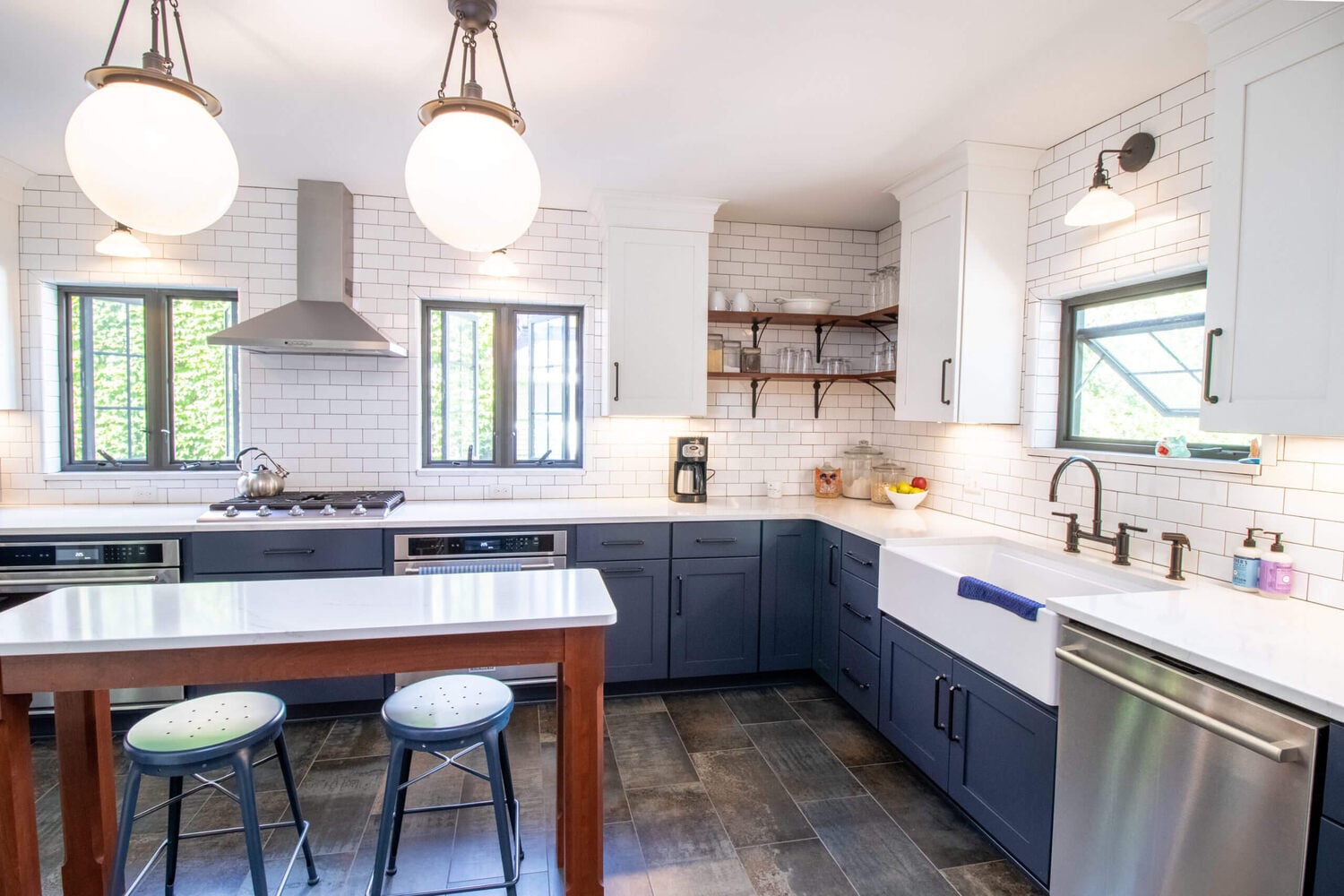 remodeled kitchen with farmhouse sink and navy cabinets by Odd Fellows Contracting in East Lansing MI