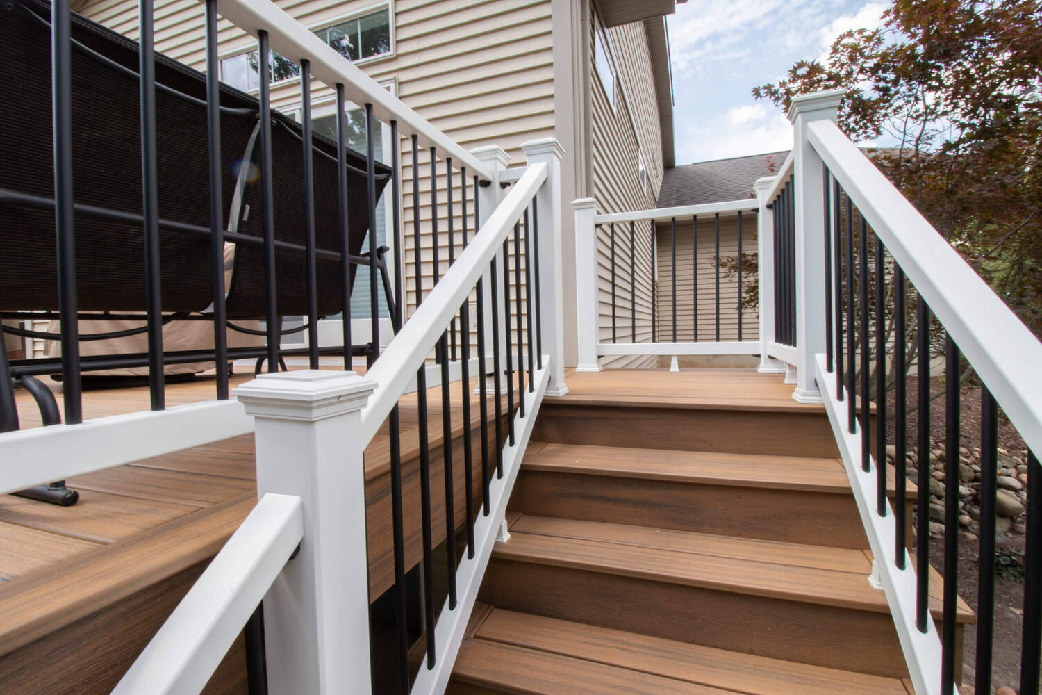 outdoor deck stairs with composite decking and modern railing installed by Odd Fellows Contracting in Williamston, MI