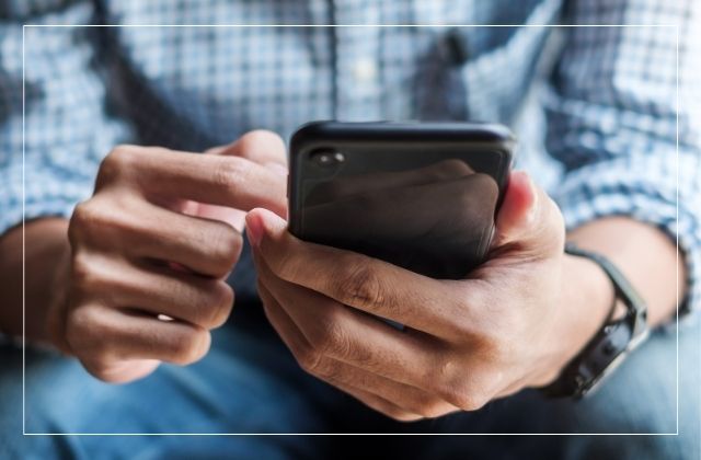 Man holding cell phone and dialing phone.  